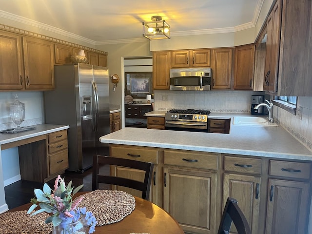 kitchen featuring tasteful backsplash, a peninsula, light countertops, stainless steel appliances, and a sink