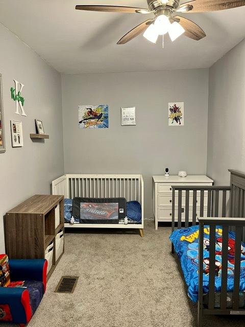 bedroom with a ceiling fan and carpet floors