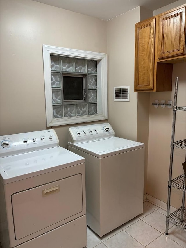 washroom featuring cabinet space, visible vents, independent washer and dryer, and light tile patterned floors