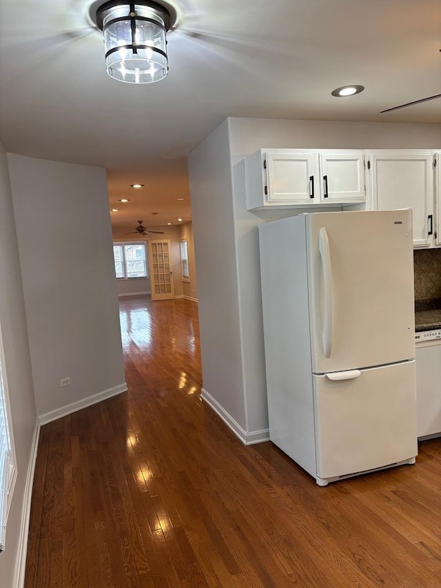 kitchen with backsplash, white cabinetry, white appliances, ceiling fan, and dark wood-type flooring