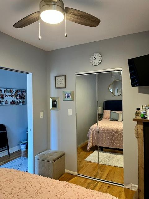bedroom featuring a closet, baseboards, ceiling fan, and wood finished floors