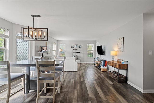 dining space with baseboards, a notable chandelier, and dark wood-style floors