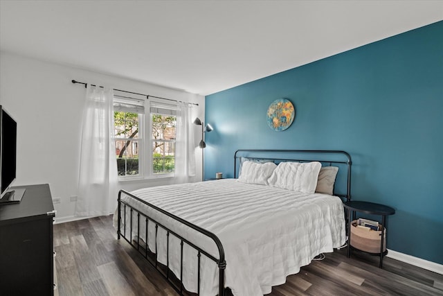 bedroom with baseboards and wood finished floors
