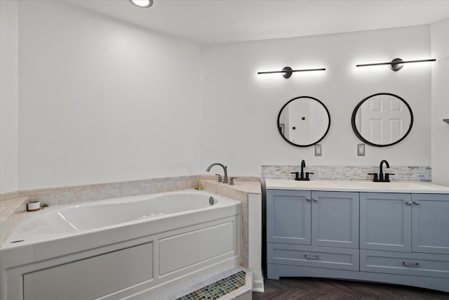 bathroom with double vanity, a bath, and a sink