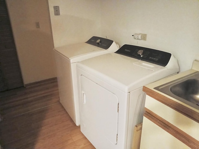 laundry area featuring laundry area, light wood-type flooring, and washing machine and clothes dryer