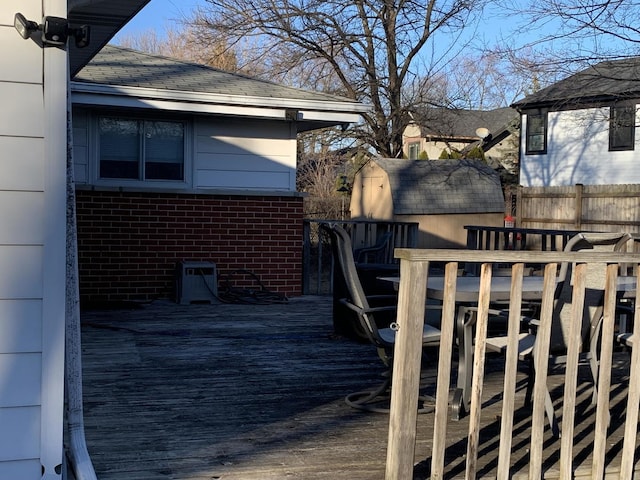 deck featuring fence, an outdoor structure, and a storage unit