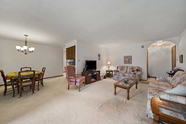 living room featuring arched walkways, a chandelier, and light carpet