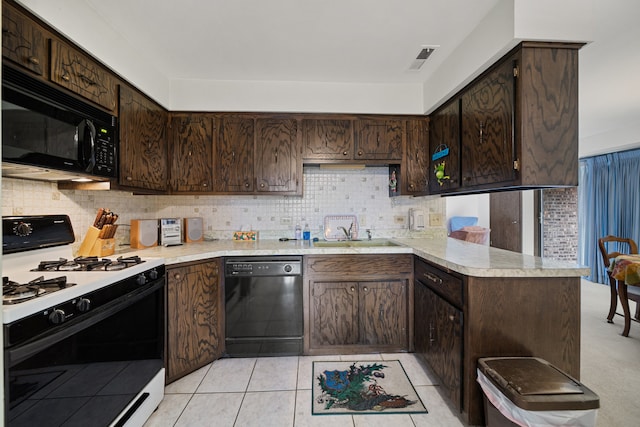 kitchen featuring a sink, dark brown cabinets, a peninsula, and black appliances