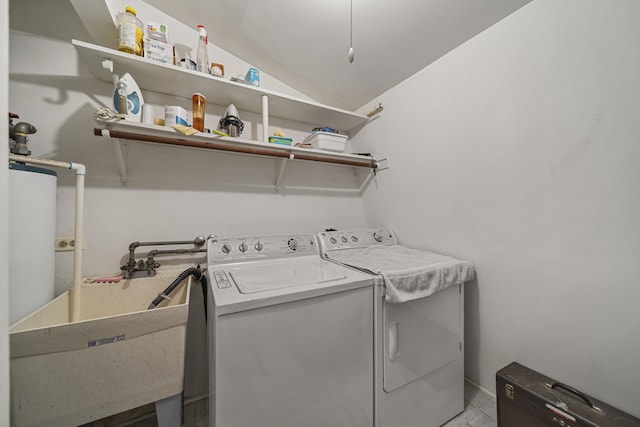 washroom with a sink, laundry area, and washer and clothes dryer