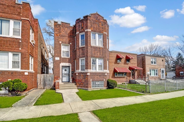view of front facade with a front yard, brick siding, and fence