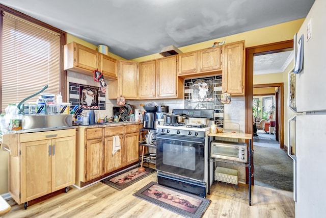 kitchen featuring light wood-style flooring, light brown cabinets, and range with gas stovetop