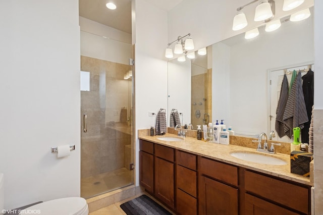 bathroom with a sink, toilet, double vanity, and a stall shower