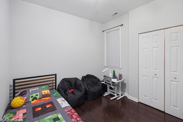 bedroom featuring visible vents, baseboards, a closet, and wood finished floors