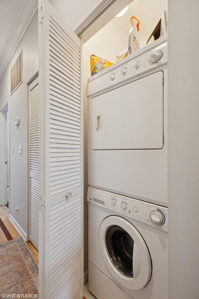 laundry room with stacked washer / dryer, laundry area, baseboards, and visible vents