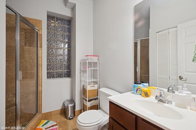 bathroom featuring vanity, a closet, tile patterned flooring, toilet, and a shower stall