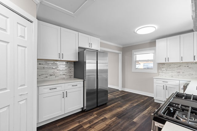 kitchen with gas stove, light countertops, white cabinets, and freestanding refrigerator