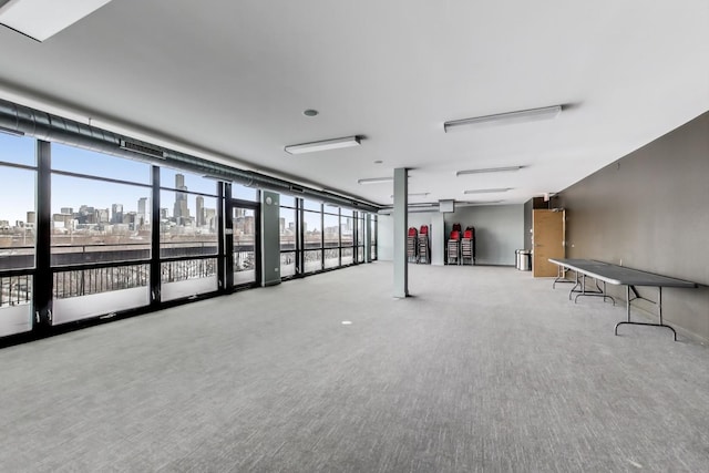 interior space featuring a view of city, a healthy amount of sunlight, and carpet