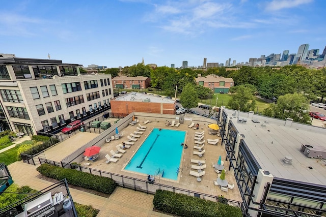 view of swimming pool featuring a view of city and fence