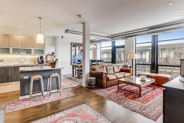 living room featuring baseboards, recessed lighting, dark wood-type flooring, and a wall of windows