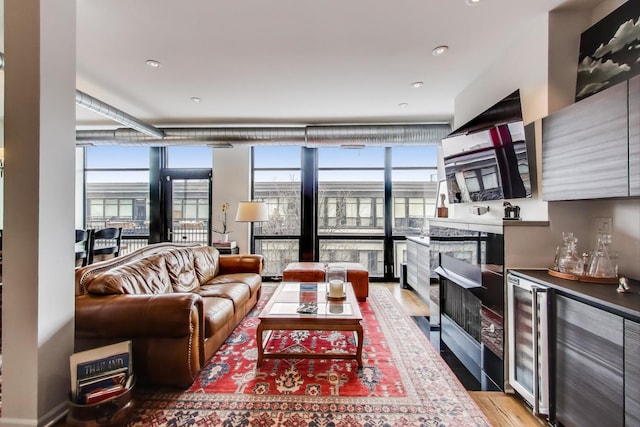 living room with plenty of natural light, a wall of windows, and light wood-style flooring