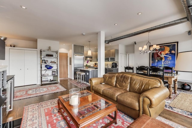 living area featuring an inviting chandelier, recessed lighting, and dark wood-style flooring