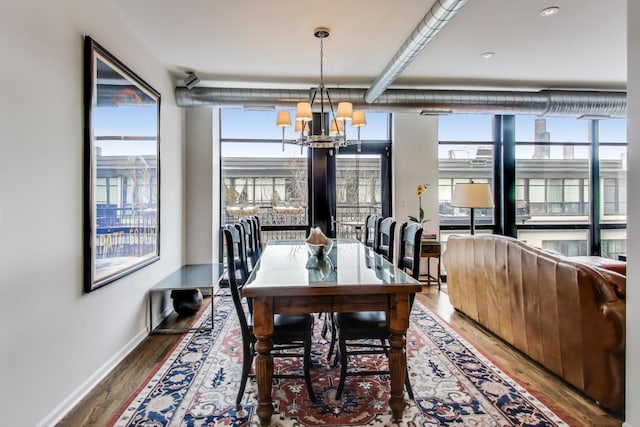 dining area featuring an inviting chandelier, baseboards, and wood finished floors