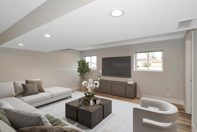 living room with baseboards, visible vents, light wood-style floors, and recessed lighting