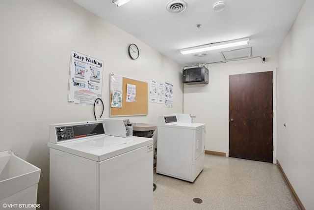 shared laundry area featuring washing machine and dryer, visible vents, baseboards, and a sink
