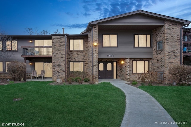view of front of house featuring a front yard and brick siding