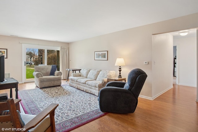 living area featuring light wood-style flooring and baseboards
