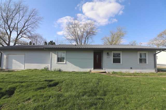 ranch-style home featuring metal roof, an attached garage, and a front lawn