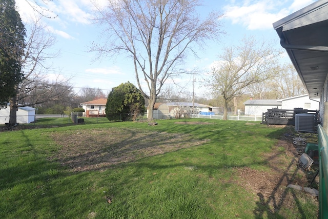 view of yard featuring central AC unit and fence