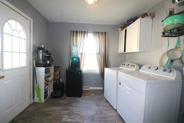 clothes washing area with cabinet space, washer and dryer, and dark wood-style floors