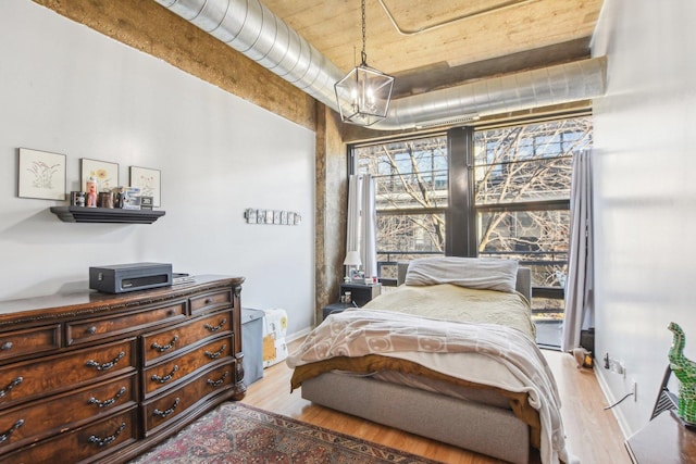 1070 W 15th St Unit 305, Chicago, IL 60608 - bedroom with wood finished floors, a chandelier, and baseboards