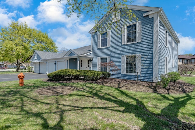 view of front of house featuring a front lawn, an attached garage, and aphalt driveway