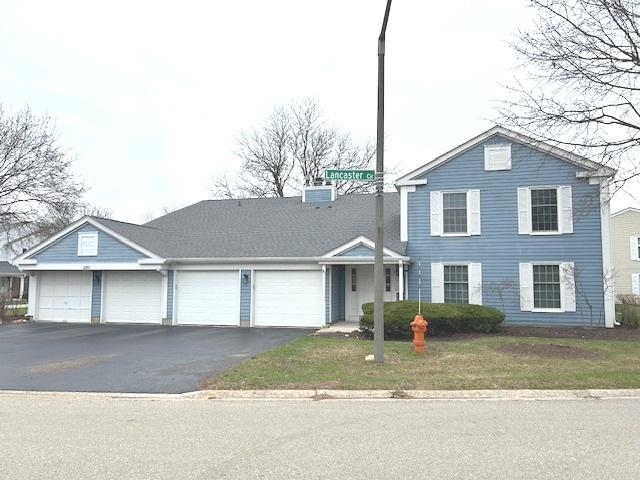 traditional-style home featuring an attached garage and driveway