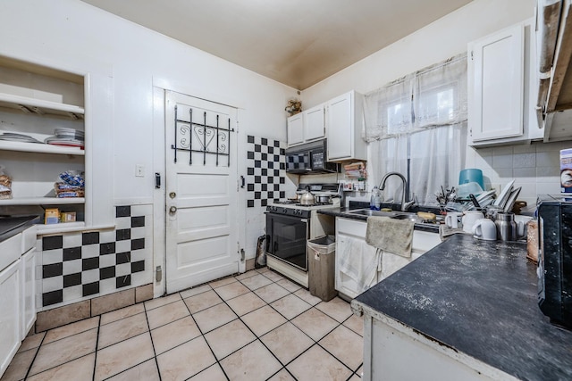 1317 N Harding Ave, Chicago, IL 60651 - kitchen with white cabinetry, a sink, light tile patterned flooring, white range with gas cooktop, and black microwave