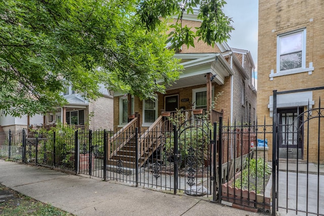 1317 N Harding Ave, Chicago, IL 60651 - view of front of house featuring a fenced front yard, covered porch, a gate, and brick siding