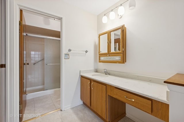 full bathroom featuring a shower stall, baseboards, vanity, and tile patterned floors