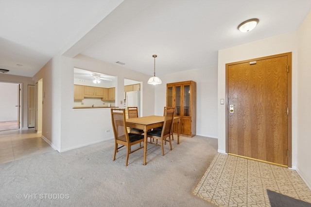 dining room featuring ceiling fan, visible vents, baseboards, and light carpet