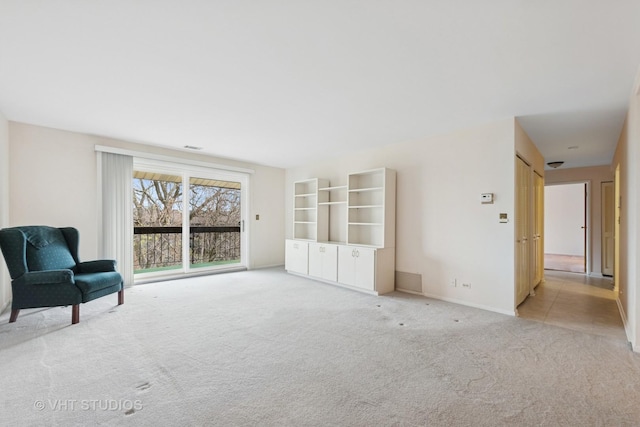 unfurnished room featuring visible vents, baseboards, and light colored carpet