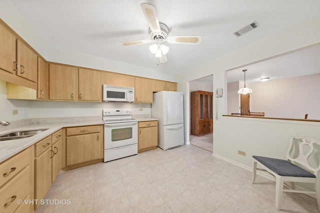 kitchen with visible vents, a sink, white appliances, and light countertops