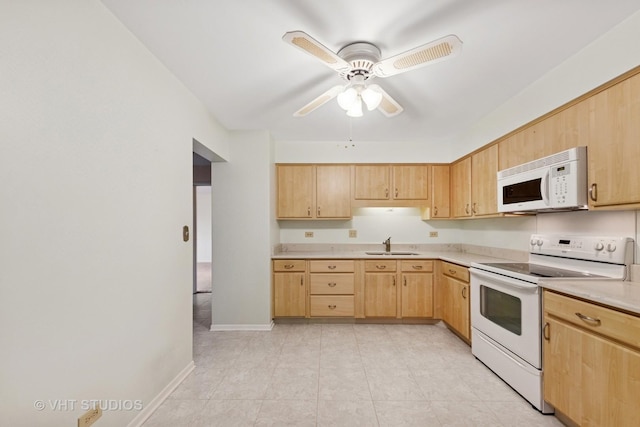 kitchen featuring light brown cabinetry, a sink, a ceiling fan, white appliances, and light countertops
