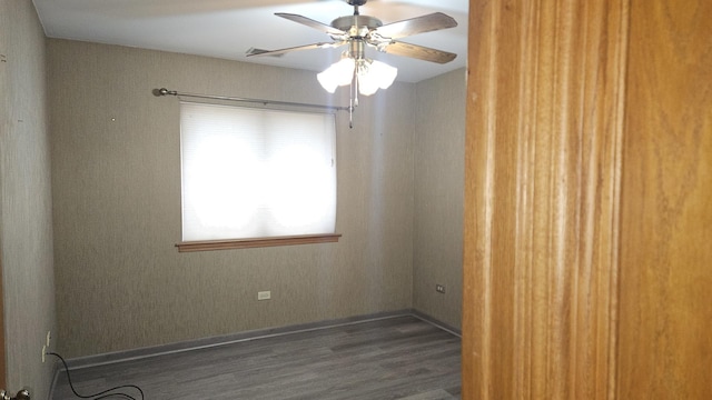 spare room featuring wood finished floors, ceiling fan, and baseboards