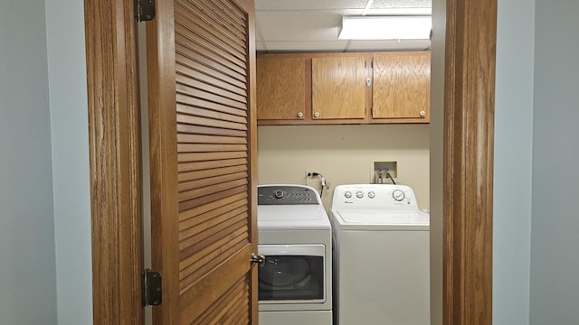 clothes washing area featuring independent washer and dryer and cabinet space