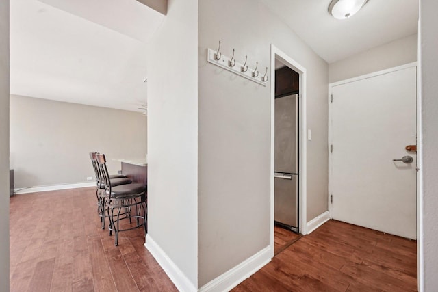 hallway featuring hardwood / wood-style floors and baseboards