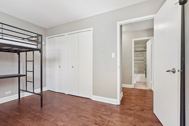 unfurnished bedroom with wood finished floors, baseboards, and a closet