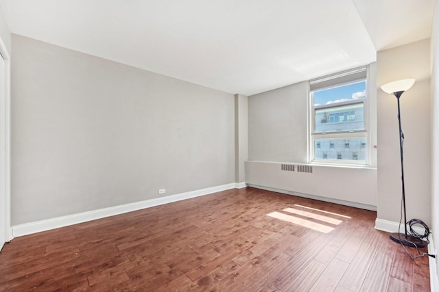 empty room with baseboards and wood finished floors