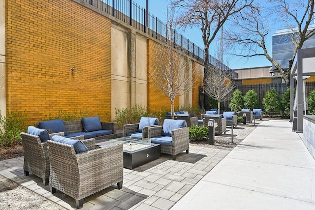 view of patio featuring fence and an outdoor living space with a fire pit