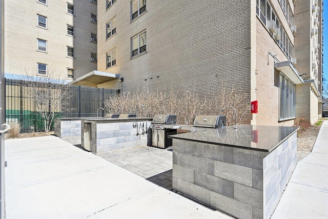 view of patio / terrace with exterior kitchen, grilling area, and fence